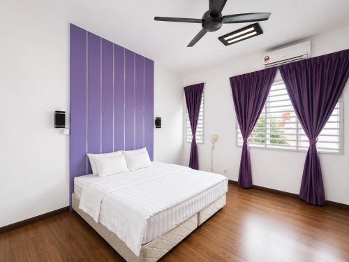 a bedroom with a white bed and purple walls at Singstay Guesthouse in Mersing