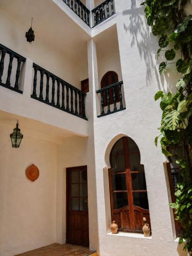 an external view of a house with two doors at JIBARI, riad luminoso con patio en la medina de Asilah in Asilah