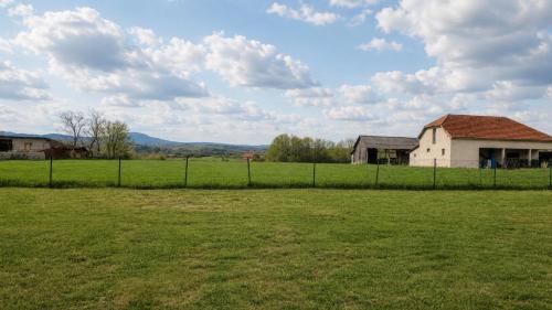 a field with a house and a fence in a field at Šumadijski Pogled in Pružatovac