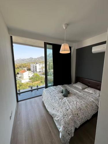 a bedroom with a bed and a large window at Hunz Homes in Ayii Trimithias