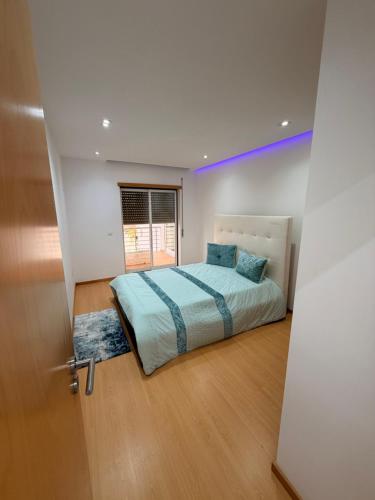 a bedroom with a bed in a room with a window at Moinho do vento in Nazaré