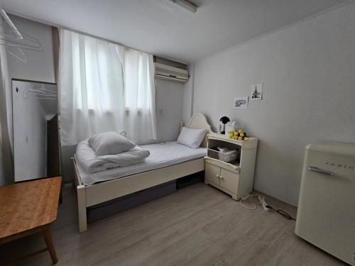 a small bedroom with a bed and a window at Dear, U in Gyeongju