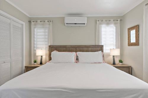 a bedroom with a large white bed with two lamps at Newly Renovated Condo in Christiansted