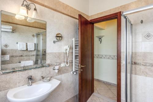 a bathroom with a sink and a mirror at Hotel Villa Ambrosina in Impruneta