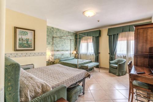 a hotel room with a bed and a desk at Hotel Villa Ambrosina in Impruneta