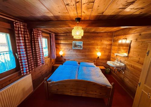 a bedroom with a bed in a wooden cabin at Ferienhaus Unterkircher-Wallner in Heiligenblut