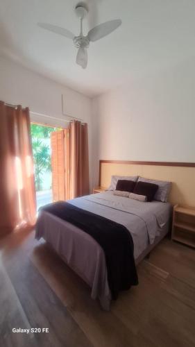 a bedroom with a large bed and a window at Pousada Guarujá, suítes Praia do tombo in Guarujá