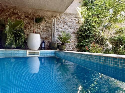 a swimming pool with a vase sitting on top of it at L'oiseau Bleu suite MERLE BLEU in Roubia
