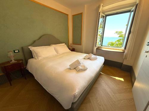 a bedroom with a large white bed with a window at Villa Tergeste in Trieste