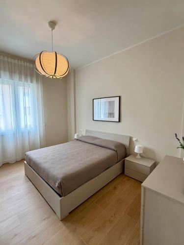 a bedroom with a large bed and a chandelier at Casa Tania in Massa