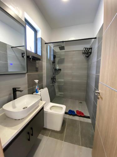 a bathroom with a toilet and a sink and a shower at Favorite Staycation by Janice - Modern Comfort Near Airport in Nairobi