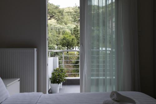 a bedroom with a bed and a large glass window at Nayra View & Spa in Kavála