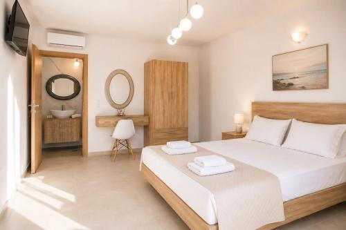 a bedroom with a large bed and a mirror at Luxury Villa John in Panormos Rethymno