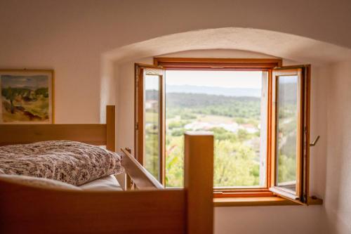 a bedroom with a bed and a large window at Štanjelski Razgledi AR in Štanjel