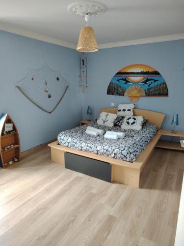 a bedroom with a bed and a blue wall at Chez Albert au bord de plage in Cherrueix