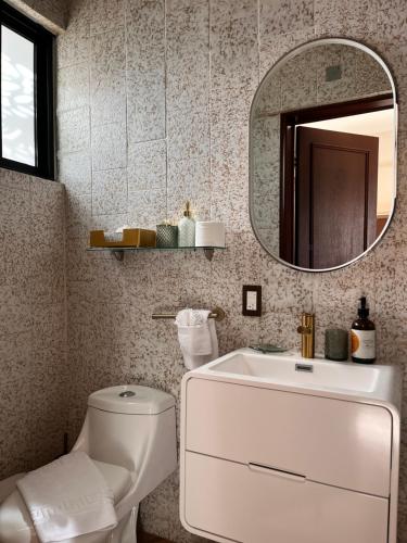 a bathroom with a white toilet and a mirror at Hotel Boutique Casa Ceibas in Cuautla Morelos