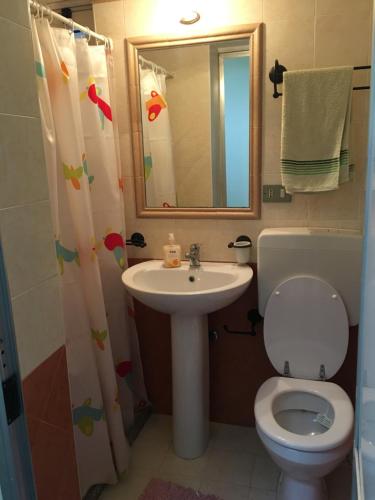 bagno con servizi igienici, lavandino e specchio di La Terrazzina a Balestrate