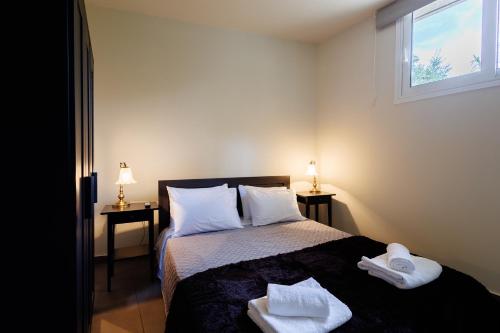 a bedroom with a bed with two towels on it at Olive and Sea Suites in Kalamata
