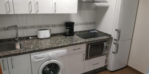 a kitchen with a washing machine and a refrigerator at Apartamentos Don Pepe in Torremolinos