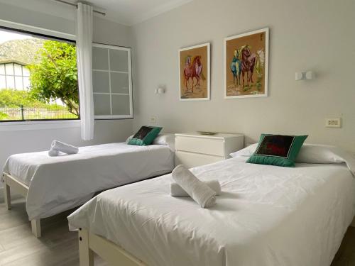 a bedroom with two beds and a window at La Choza in Oriñón