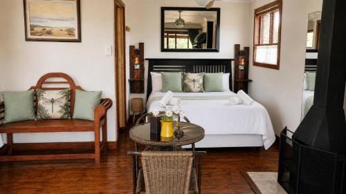 a bedroom with a bed and a table and a chair at Riverman Cabin Country Lodge - Tonteldoos in Tonteldoos