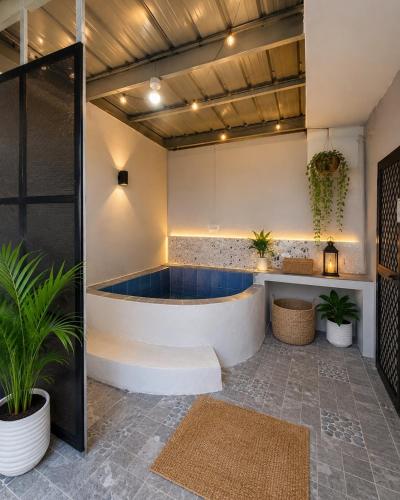 a bathtub in the middle of a room with plants at The Lake Haus Cebu in Lapu Lapu City