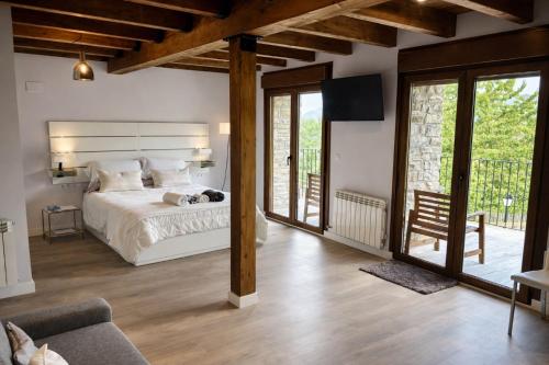 a bedroom with a large bed and a balcony at La Era de Lardiés in Lardiés