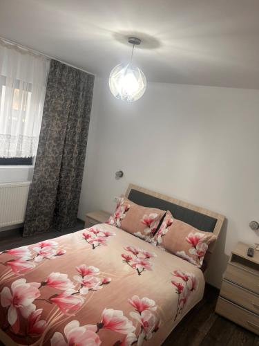 a bedroom with a bed with pink flowers on it at D&D New Residence in Piteşti