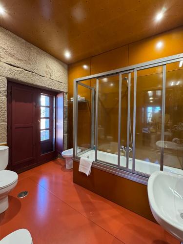 a bathroom with two sinks and a toilet at Pousada Torre Lombarda in Allariz