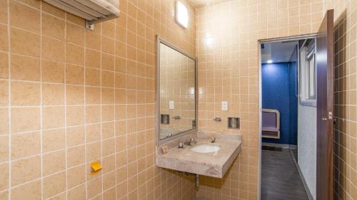 ein Badezimmer mit Waschbecken und Spiegel in der Unterkunft Hotel Menara in Mexiko-Stadt
