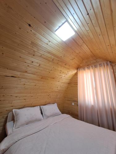 a bedroom with a bed in a wooden ceiling at "AILUN" Issyk Kul in Tong