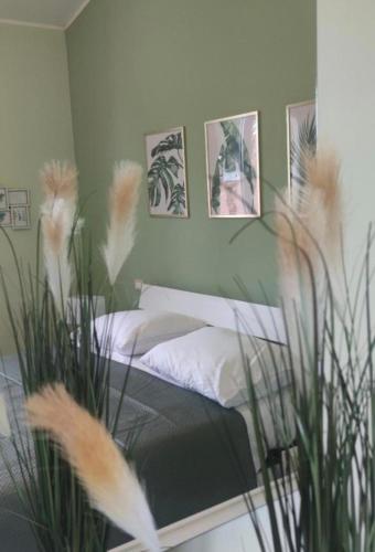 a bedroom with a bed and some plants and pictures at Camera matrimoniale - Villa Dalila in Silvi Paese