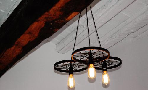 a black chandelier with lights hanging from a ceiling at Groc Rooms in La Seu d'Urgell