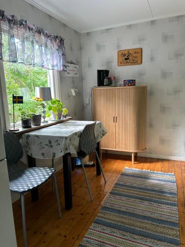 a dining room with a table and chairs and a window at The Hunters Hill - Cosy private forest retreat in Brålanda