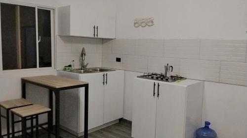 a kitchen with white cabinets and a sink and a counter at Xamanai Playa Rincón III in Las Galeras