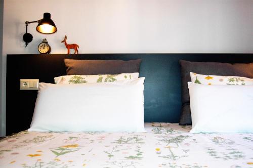 a bedroom with a bed with white sheets and a headboard at Groc Rooms in La Seu d'Urgell