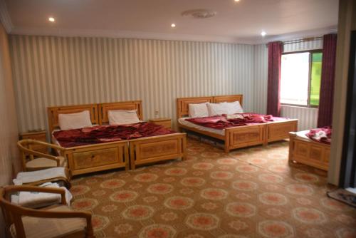 a bedroom with two beds and a window at Pine Hills, Naran in Naran