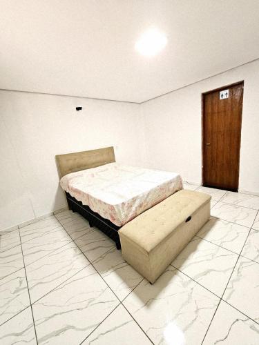a bedroom with a bed and a wooden door at Chácara Recanto gramado in Tatuí