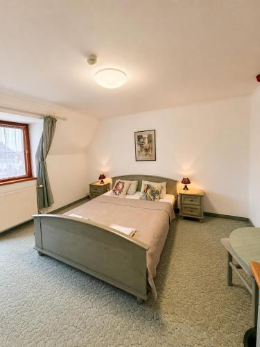a bedroom with a large bed and two tables at Éden Panzio in Bük