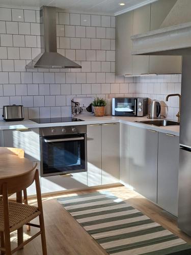 a kitchen with stainless steel appliances and a table at Lönngården in Kristinestad