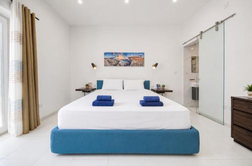 a bedroom with a large bed with blue cushions at Modern Duplex Apartment with Private Pool & AC Central Malta in Balzan