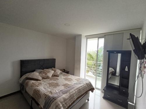 a bedroom with a bed and a television and a balcony at Gran Vista in Fusagasuga