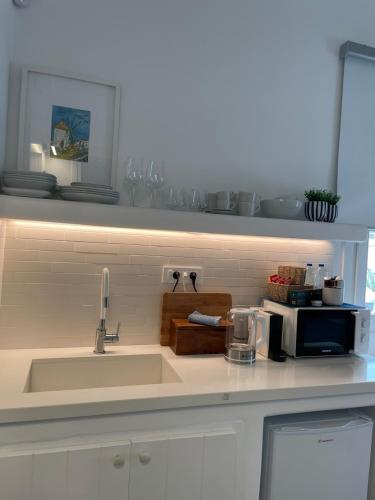 a kitchen counter with a sink and a microwave at Gemelos Cozy Stay in Megali Ammos