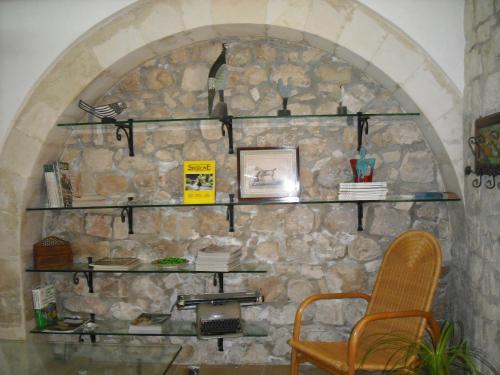 a stone wall with shelves and a chair at Dammuso Bouganville in Scicli