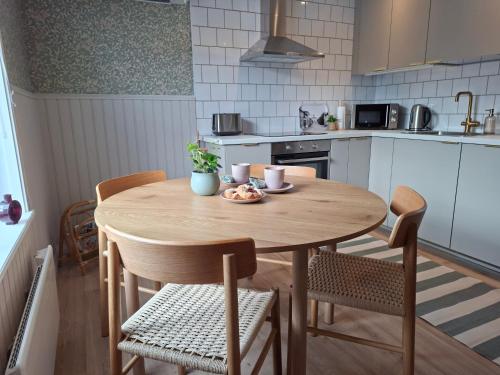 a kitchen with a wooden table and chairs at Lönngården in Kristinestad