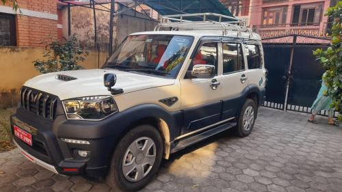 a white and blue jeep parked on a street at My Car in Pokhara