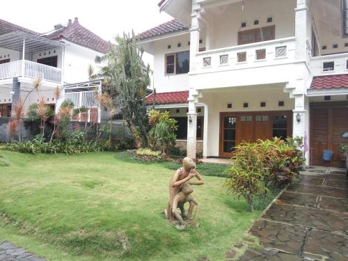 a statue of a man standing in the yard of a house at Villa Ohana Batu in Batu