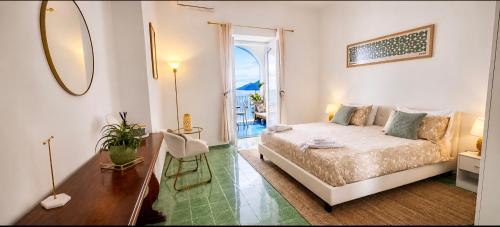 a white bedroom with a bed and a mirror at Casa Intiso - Two double bedroom apartment in Positano