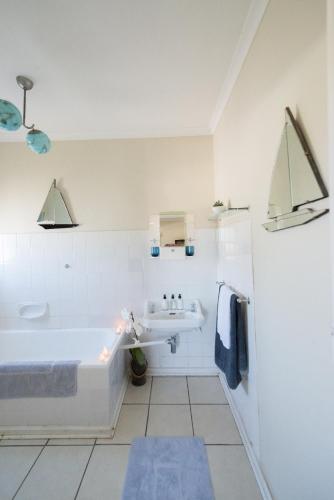 a white bathroom with a tub and a sink at Classic Lodge - Cape Dutch Quarters in Tulbagh