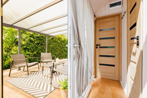 a door to a patio with chairs and a table at Tiny House in Mechelinki